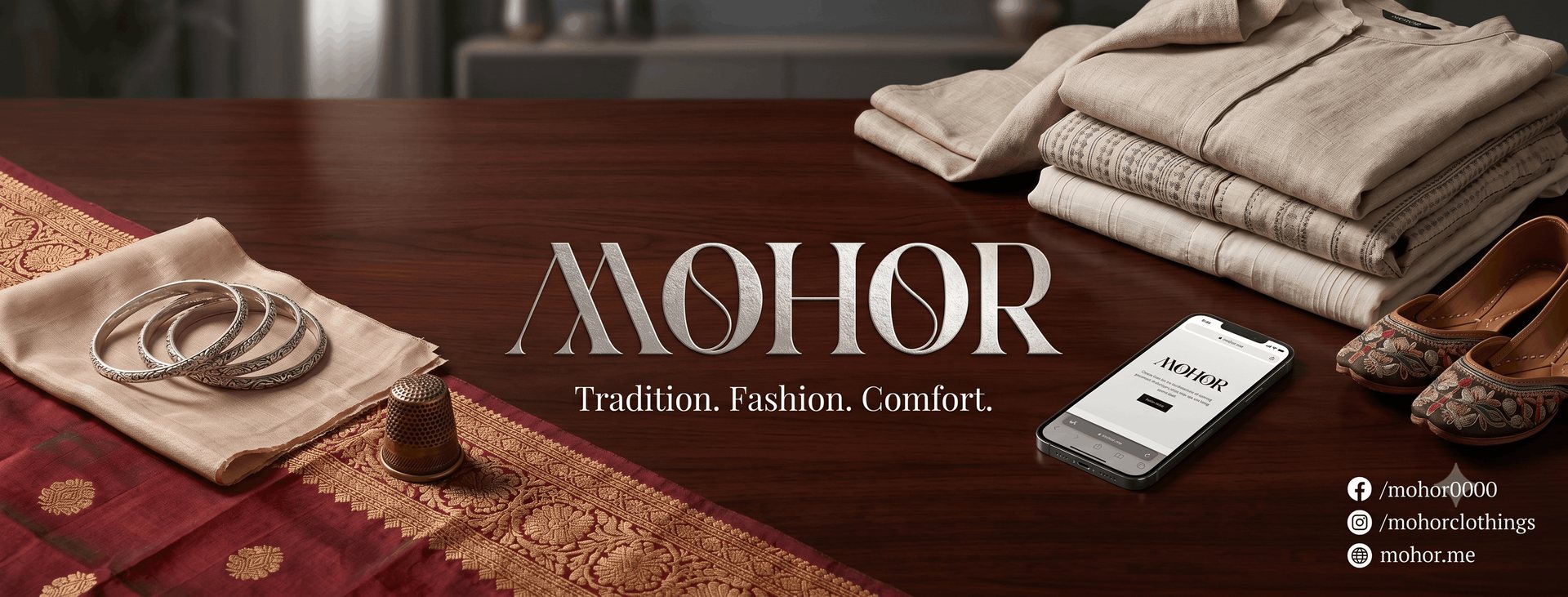 Mohor Clothings — Tradition, Fashion, Comfort. Folded khadi fabric, silver bangles and a Banarasi saree border on a mahogany table.